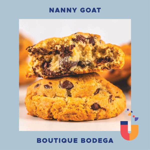 A close-up of two chocolate chip cookies, one split open to reveal the gooey texture inside, showcasing bakery goods available at Nanny Goat Boutique Bodega.